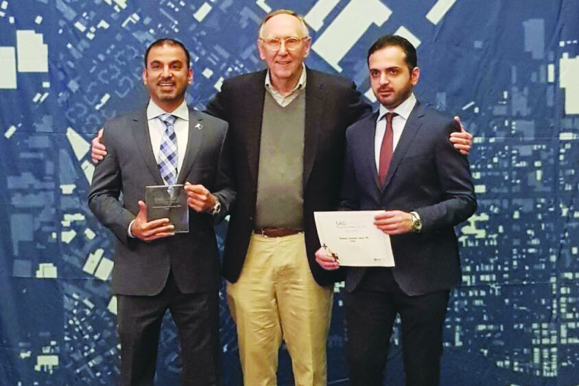 Aref Hassan Ibrahim, Director of Technical Affairs at the National Command Center, and Captain Hassan Ali Al Malki, Head of GIS Division, receiving the award from Jack Dangermond, CEO of ESRI, US.