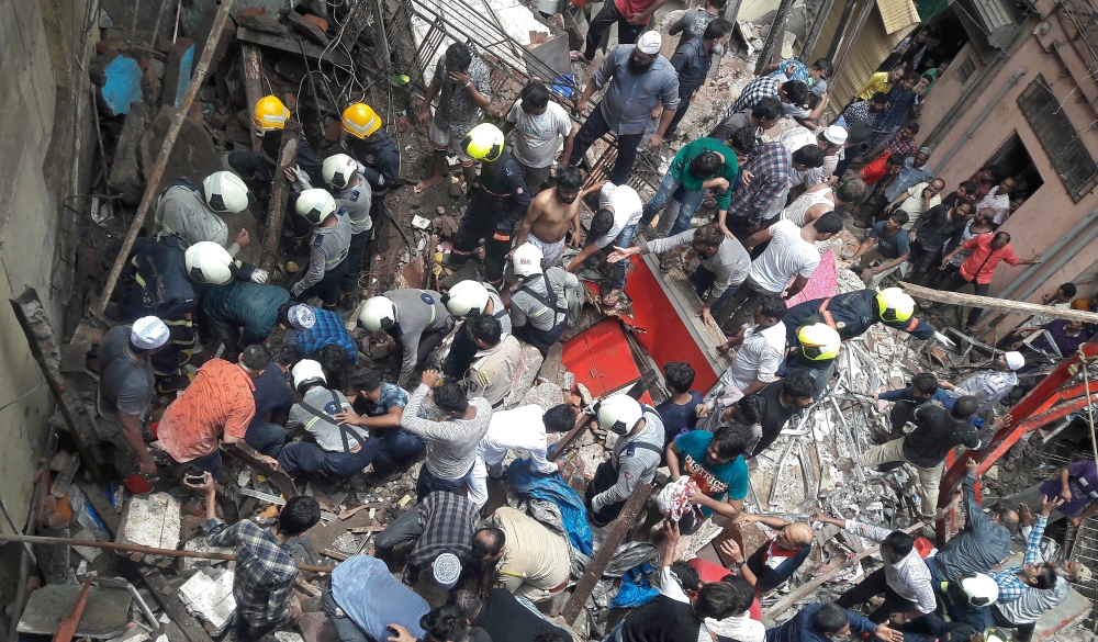 Rescue workers and residents search for survivors at the site of a collapsed building in Mumbai, India, July 16, 2019. REUTERS/Stringer 