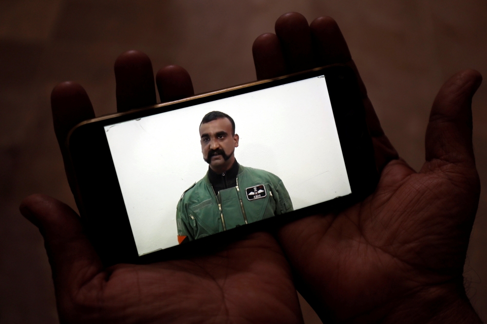 FILE PHOTO: A man watches a statement of Indian Air Force pilot Abhinandan Varthaman on his mobile phone, released on twitter by the Ministry of Information and Broadcasting in Karachi, March 1, 2019. Reuters/Akhtar Soomro