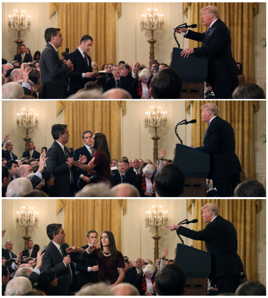 FILE PHOTO: A White House staff member reaches for the microphone held byJim Acosta of  CNN as he questions Donald Trump during a news conference, November 7, 2018. Reuters/Jonathan Ernst