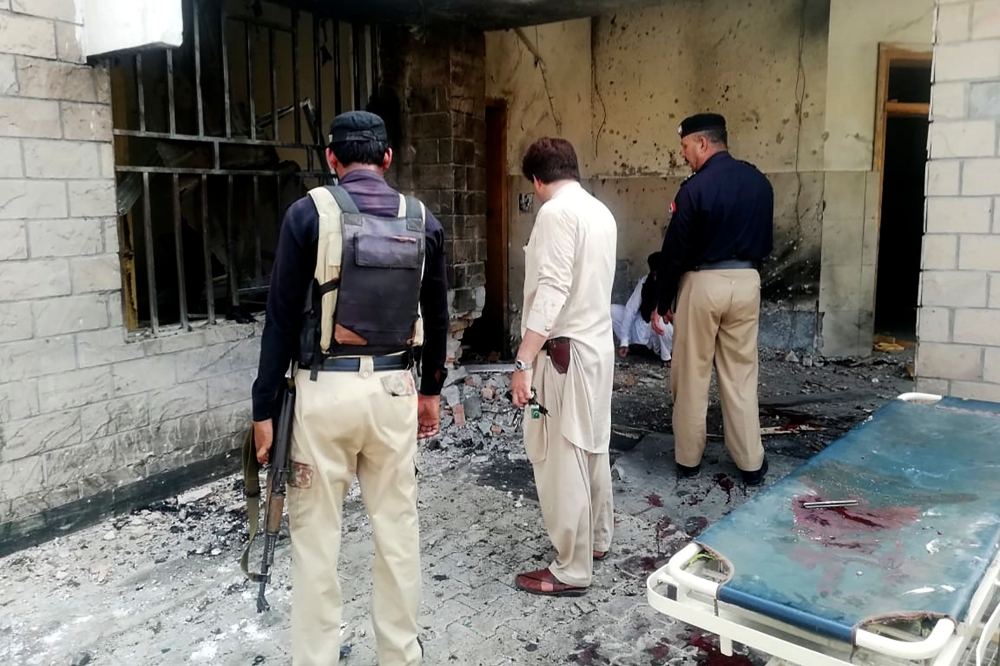 Pakistani security officials examine the site of a suicide bomb attack at the entrance of a hospital in Kotlan Saidan village on the outskirts of the northwestern city of Dera Ismail Khan on July 21, 2019. (AFP / Adil Mughal)