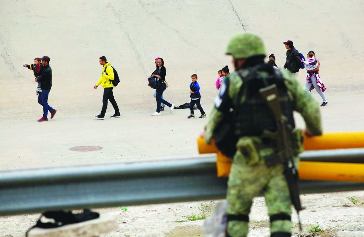 A member of the Mexican National Guard observes a group of migrants that crossed into El Paso, Texas, U.S., as seen from Ciudad Juarez, Mexico July 22, 2019. Reuters/Jose Luis Gonzalez