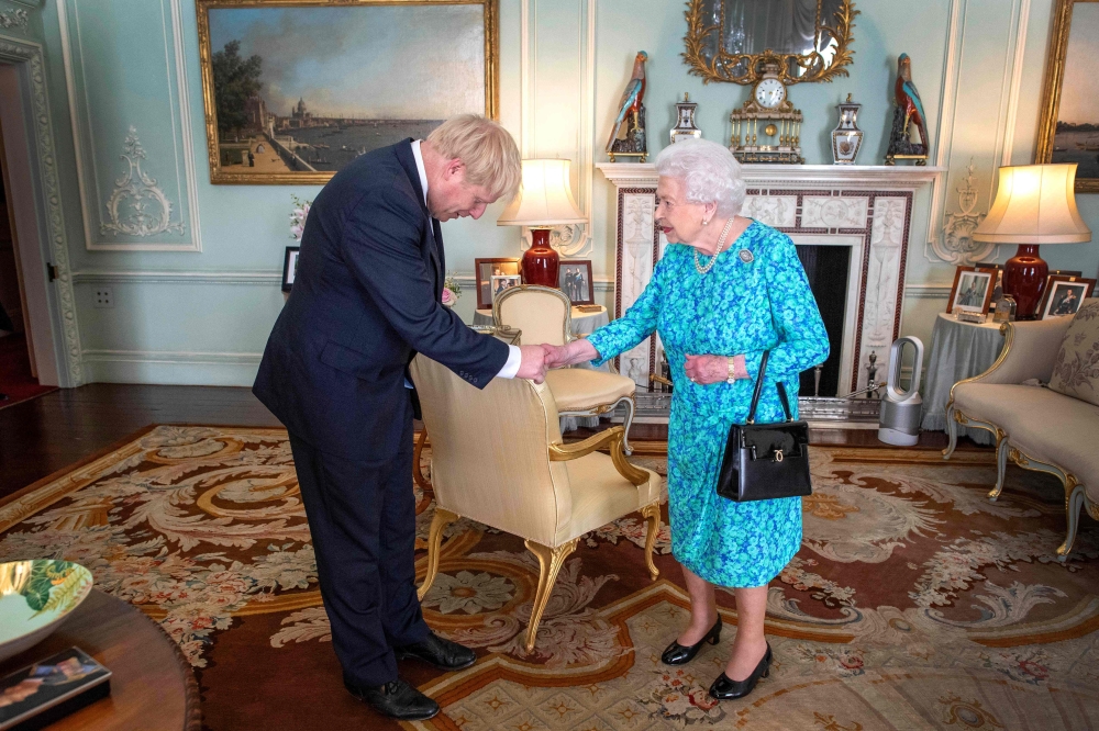 Britain's Queen Elizabeth II welcomes newly elected leader of the Conservative party, Boris Johnson during an audience in Buckingham Palace, London on July 24, 2019, where she invited him to become Prime Minister and form a new government. (AFP / POOL / V
