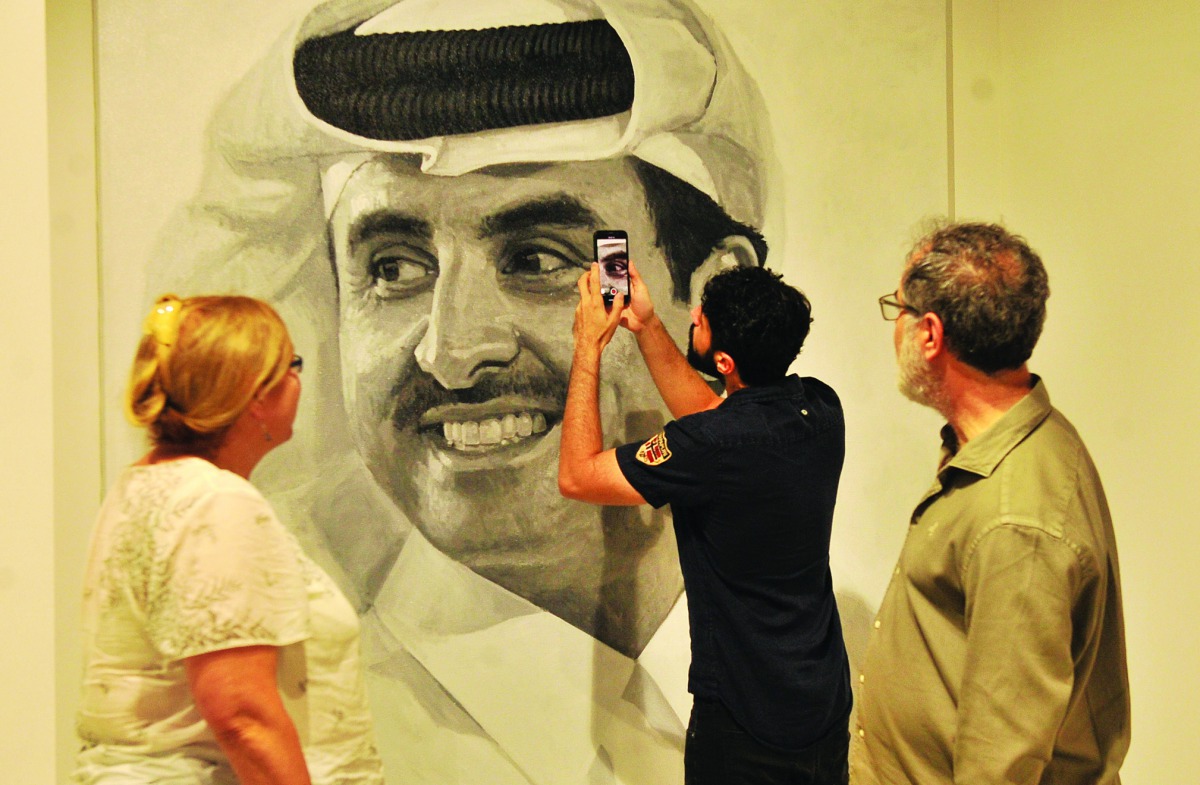 Visitors watching a monumental portrait of Amir H H Sheikh Tamim bin Hamad Al Thani by one of Iraq’s best known artists, Ismail Azzam, at “Summer Collection Part 14” exhibition at Al Markhiya Gallery at the Fire Station on Wednesday.  Pic: Baher Amin/The 