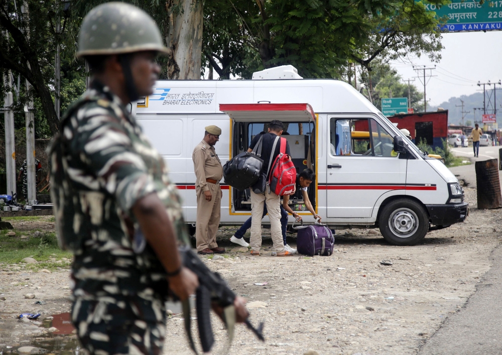 An Indian security forces personnel stands guard as Jammu Kashmir police men check the luggage and vehicles of commuters on the Jammu-Srinagar National highway at Nagrota some 25 kms from Jammu on August 2, 2019. (AFP / Rakesh BAKSHI)