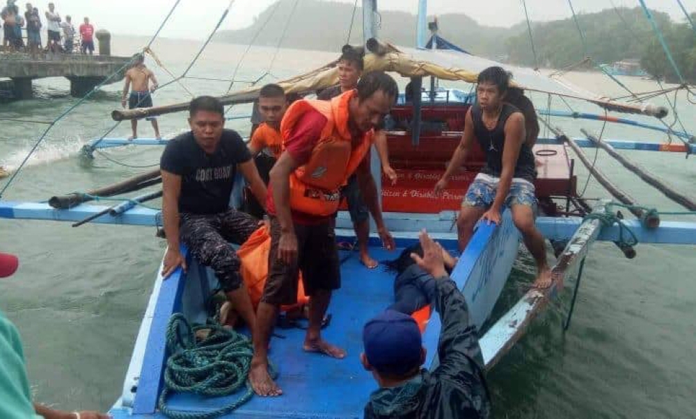 Fishermen carrying a dead body of a victim after a boat accident that happened in Iloilo-Guimaras Strait. 