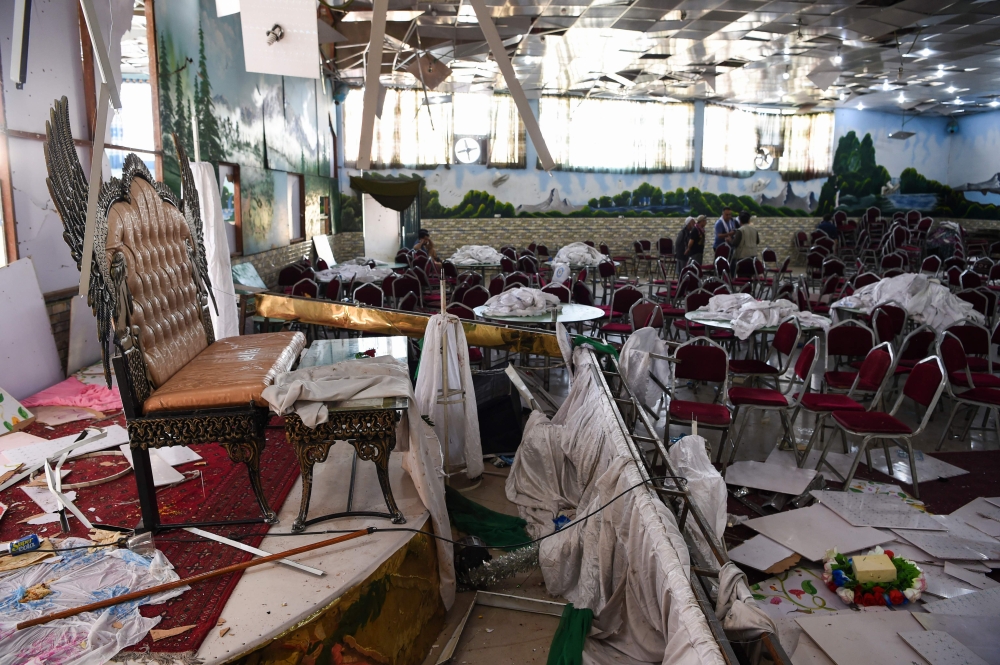 Afghan men investigate in a wedding hall after a deadly bomb blast in Kabul on August 18, 2019.   AFP / Wakil KOHSAR