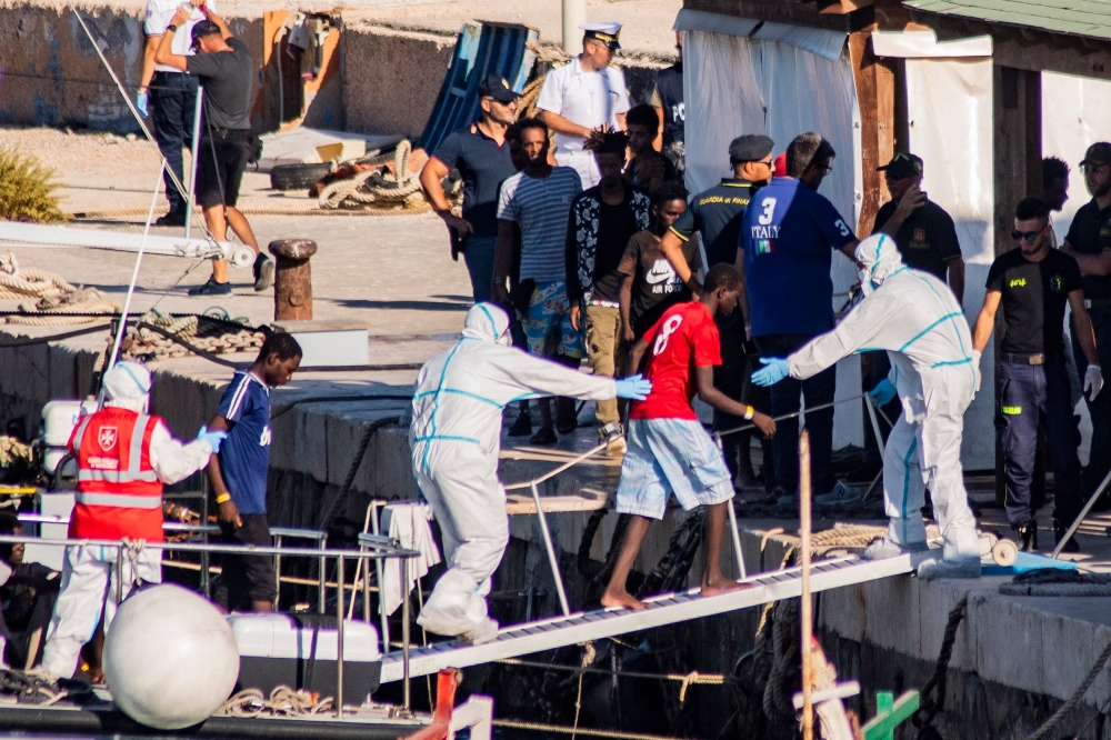 One of the twenty-seven unaccompanied minors aboard the Guardia di Finanza boat arrive at Italian island of Lampedusa on August 17, 2019 after being evacuated off the Spanish migrant NGO rescue ship Open Arms, moored off the coast of the island. AFP / Ale