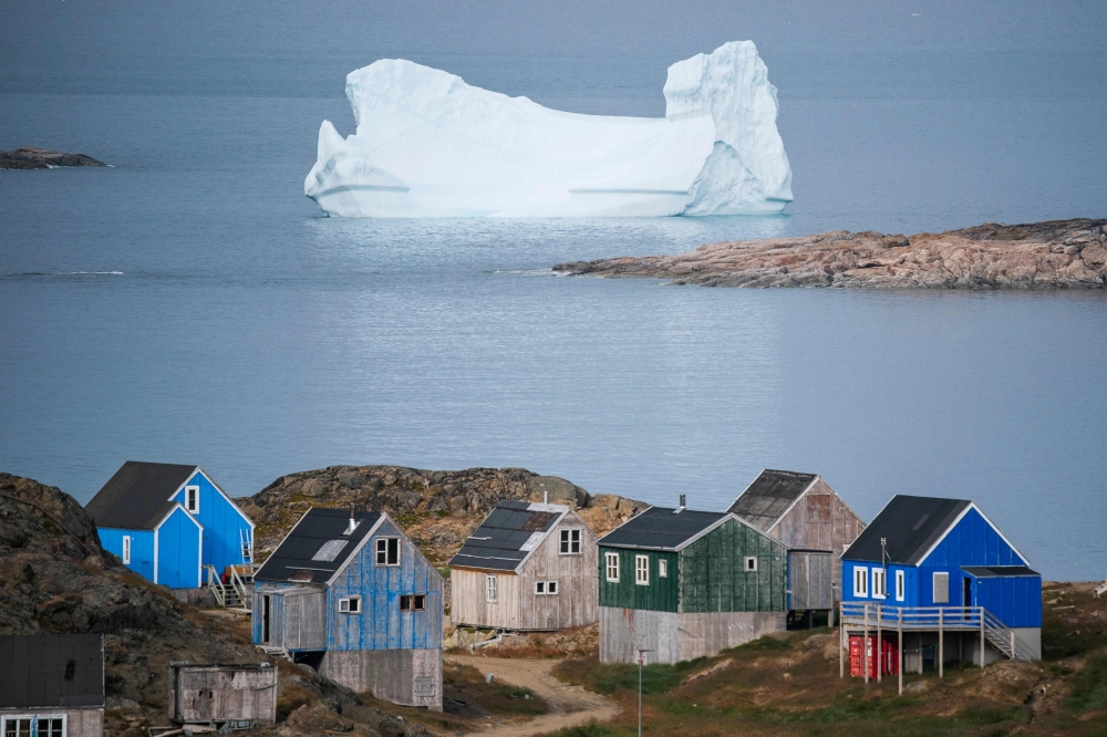 Icebergs float behind the town of Kulusuk in Greenland on August 19, 2019.  AFP / Jonathan NACKSTRAND