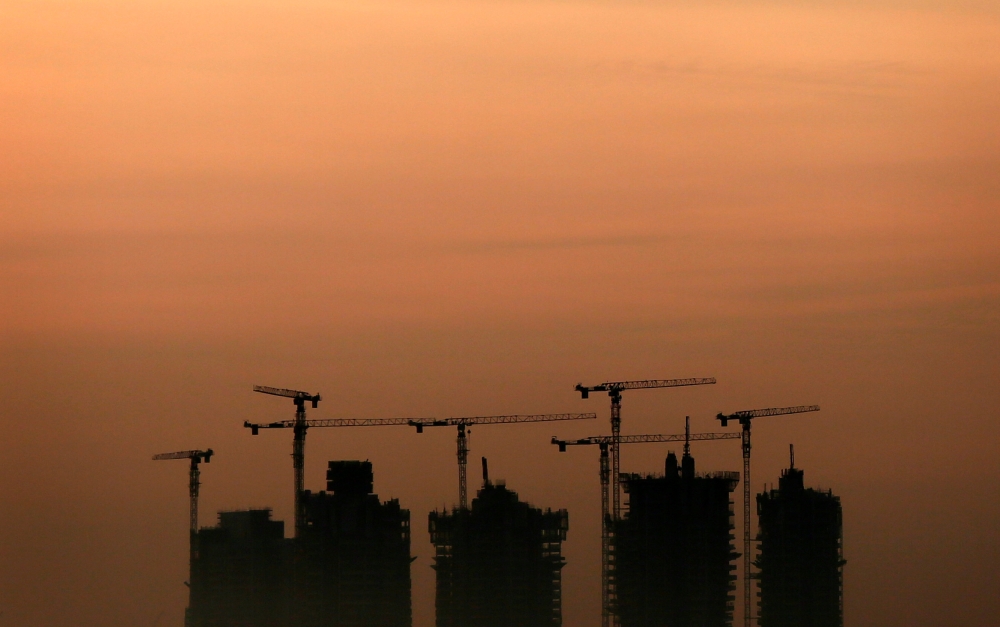 Cranes stand above an apartment complex under construction in Singapore, May 15, 2013. Reuters / Tim Wimborne