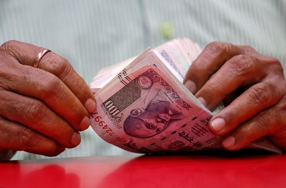 A man counts Indian currency notes inside a shop in Mumbai, August 13, 2018. Reuters/Francis Mascarenhas