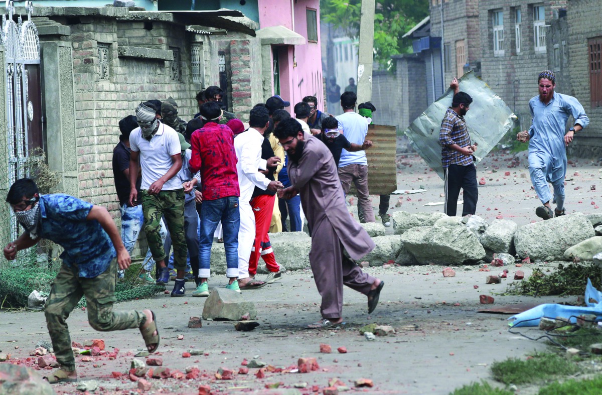Kashmiris take cover as Indian security forces (unseen) fire teargas shells during clashes, after scrapping of the special constitutional status for Kashmir by the Indian government, in Srinagar, August 30, 2019. Reuters/Danish Ismail