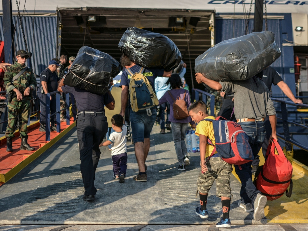 Refugees and migrants board a ship at the port of Mytilene, on the island of Lesbos on September 2, 2019, as hundreds of migrants leave Lesbos, helping to ease overcrowding at the Moria camp. AFP / STRINGER