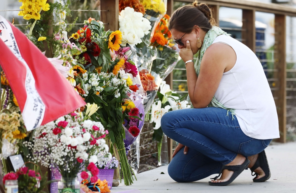 A woman looks emotional as she kneels at a makeshift memorial in Santa Barbara Harbor for victims of the Conception boat fire on September 3, 2019 in Santa Barbara, California. Mario Tama/Getty Images/AFP 