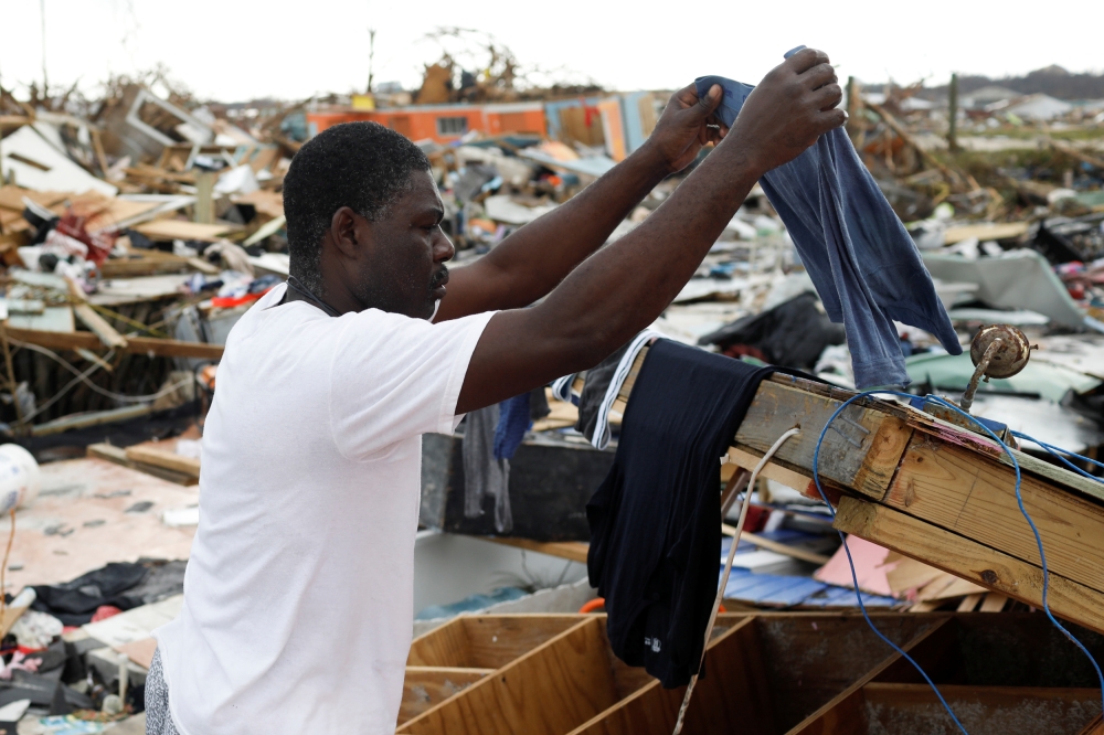 A man hangs his clothes after washing them at the Mudd neighborhood, devastated after Hurricane Dorian hit the Abaco Islands in Marsh Harbour, Bahamas, September 6, 2019. Reuters/Marco Bello
 