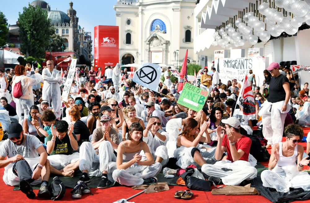 Climate activists are seen on a red carpet. REUTERS/Piroschka van de Wouw