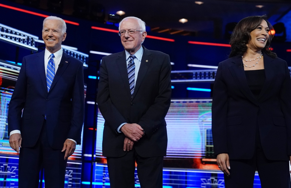 Joe Biden, Bernie Sanders and Kamala Harris pose before the start of the second US 2020 presidential election Democratic candidates debate in Miami, June 27, 2019. Reuters / Carlo Allegri