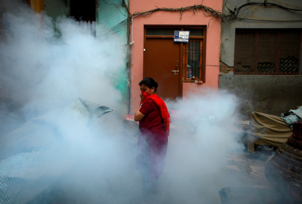 A woman covers her face amid fumigation to prevent the spread of the dengue fever and other mosquito-borne diseases in Kathmandu, September 5, 2019. Reuters/Navesh Chitrakar