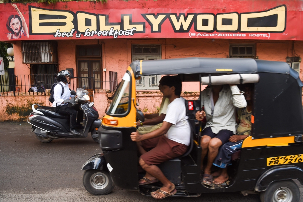 Commuters go past a hostel named 'Bollywood' in Mumbai on September 16, 2019. AFP / Indranil Mukherjee