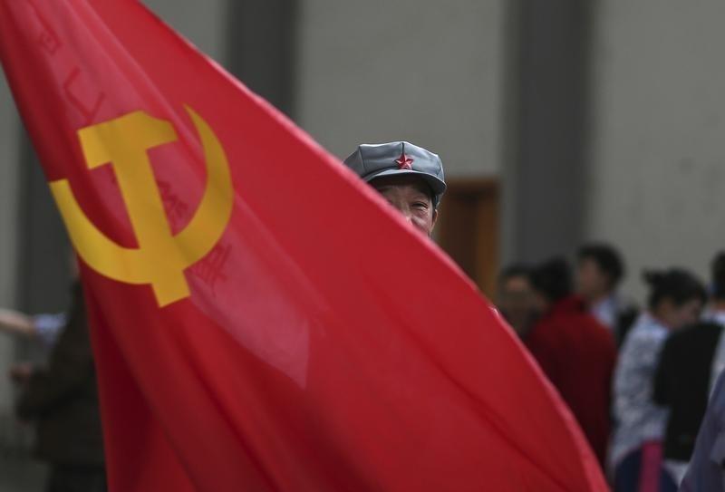 A participant waves a Chinese Communist Party flag as he waits backstage before his performance at a line dancing competition in Kunming Yunnan province, January 31, 2015. Reuters