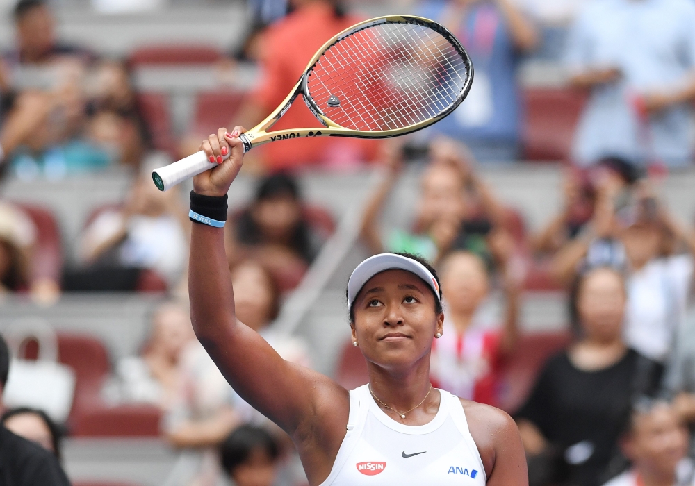 Naomi Osaka of Japan waves to the crowd after winning her women's singles third round match against Alison Riske of the US at the China Open tennis tournament in Beijing on October 3, 2019. / AFP / GREG BAKER 