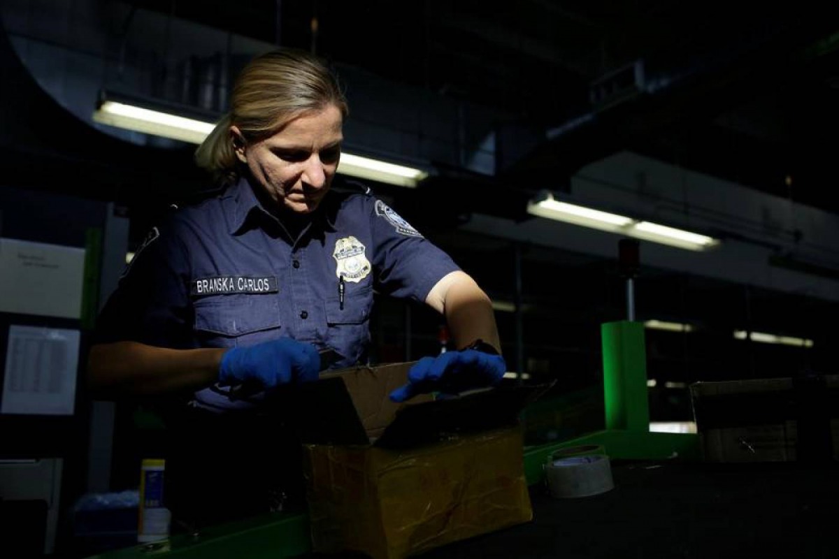 A US Customs and Border Protection officer inspects a package arriving at the International Mail Facility at O'Hare International Airport in Chicago, Illinois, U.S. November 29, 2017. Reuters/Joshua Lott