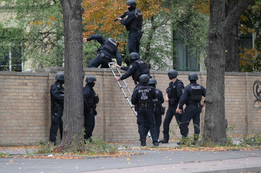 Policemen climb over a wall close to the site of a shooting in Halle an der Saale, eastern Germany, on October 9, 2019. Germany OUT / AFP / dpa / Sebastian Willnow