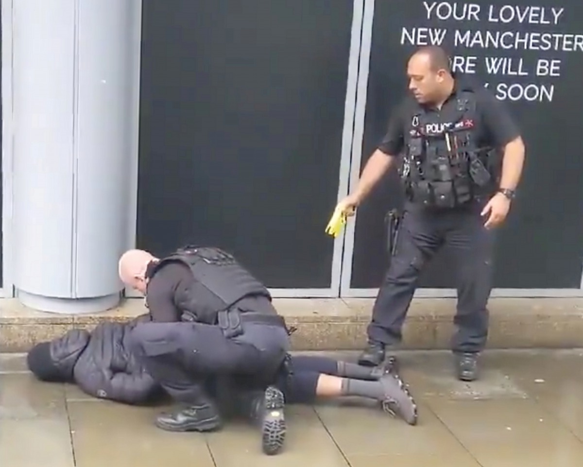 A police officer points a taser while the other holds a man down outside Arndale shopping center, where several people have been stabbed, in Manchester, Britain October 11, 2019 in this still image taken from a social media video. (JOHN GREENHALGH via REU