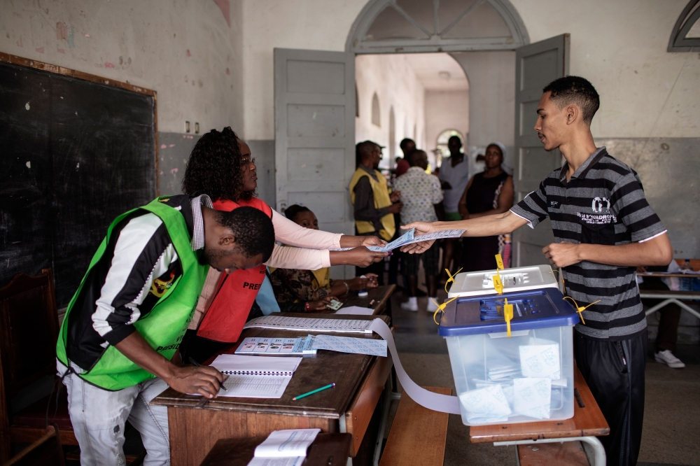 A Mozambican man receives his ballot at a voting station in a school during the Mozambican General Elections on October 15, 2019 in Maputo, Mozambique. / AFP / GIANLUIGI GUERCIA
