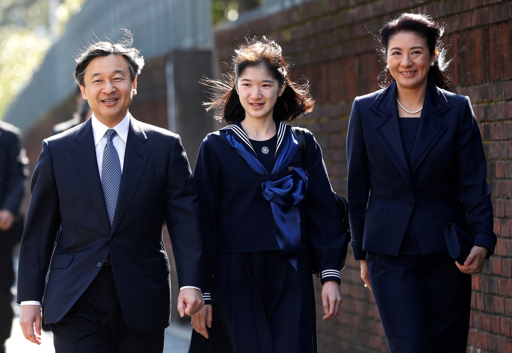 FILE PHOTO: Japan's Princess Aiko (C), accompanied by her parents Crown Prince Naruhito and Crown Princess Masako, arrives at her graduation ceremony at the Gakushuin Girls' Junior High School in Tokyo, Japan, March 22, 2017. REUTERS/Issei Kato/File Photo