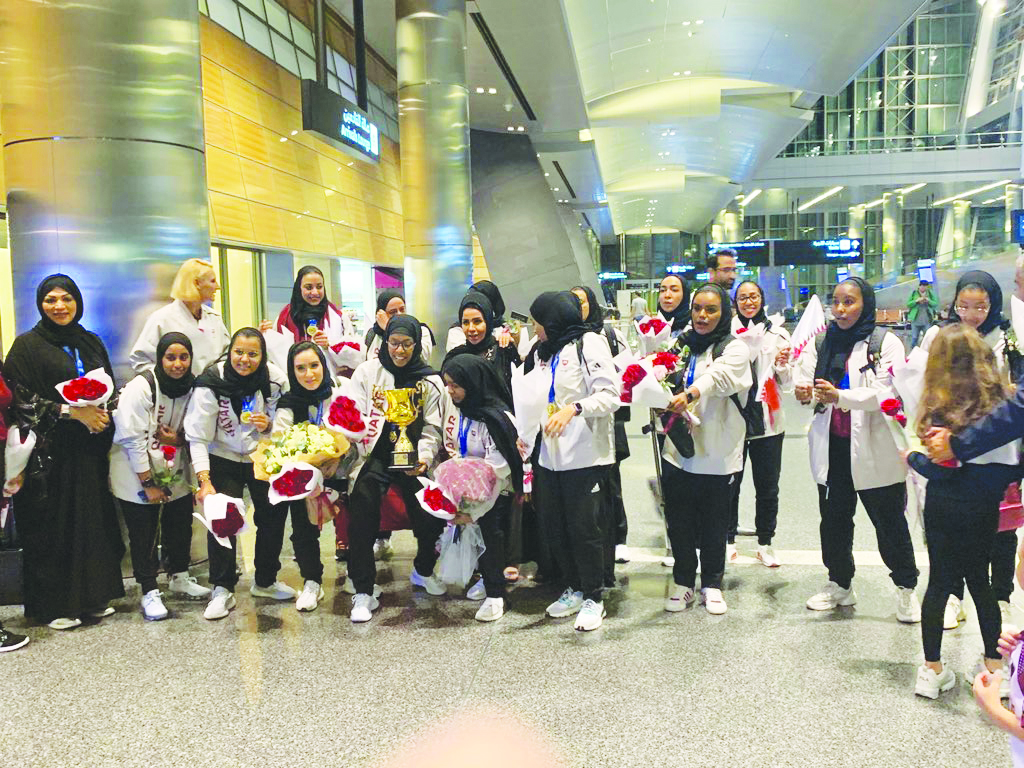 Qatar basketball team’s players and officials pose for a group photo upon their return at the Hamad International Airport.