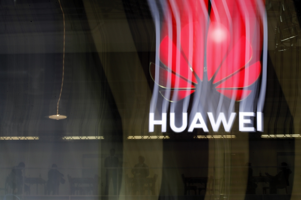 In this file photo taken on October 15, 2019 an illuminated Huawei sign is on display during the 10th Global mobile broadband forum hosted by Huawei in Zurich