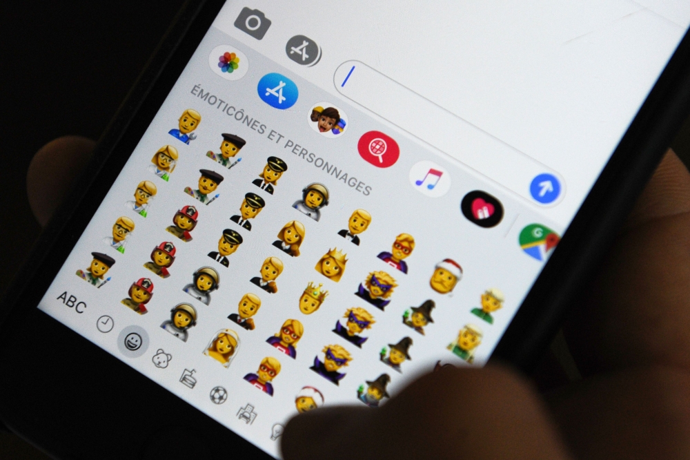 A person holds an iphone showing emojis in Hong Kong, on October 30, 2019.