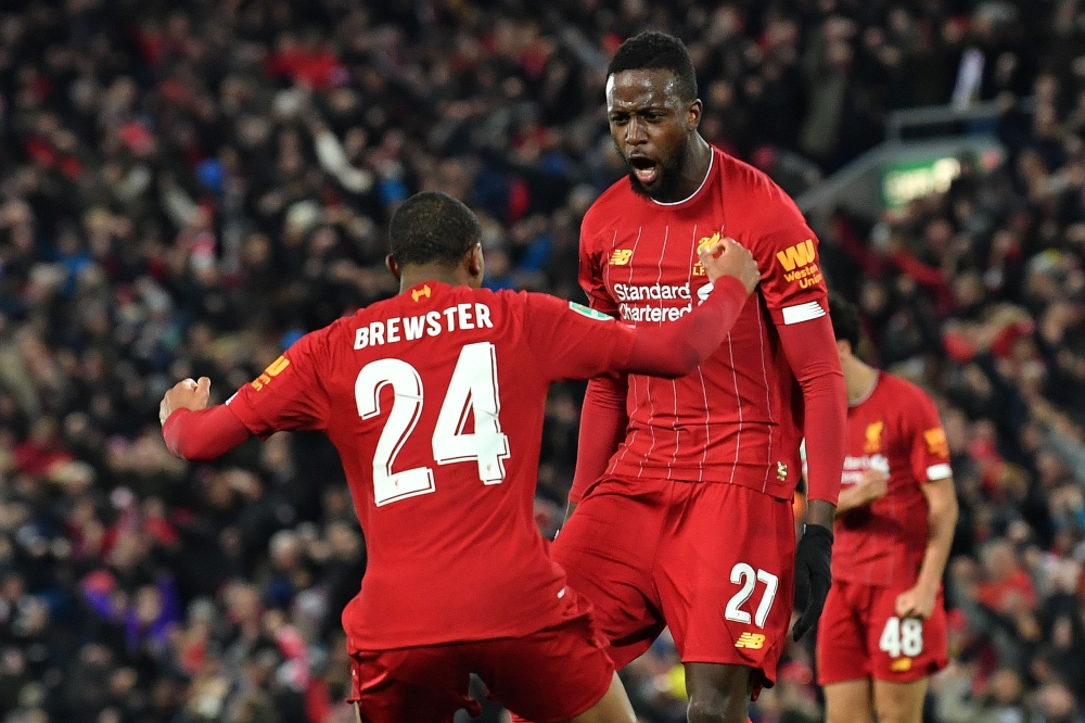 Liverpool's Belgium striker Divock Origi celebrates scoring his team's fourth goal with Liverpool's English striker Rhian Brewster during the English League Cup fourth round football match between Liverpool and Arsenal at Anfield in Liverpool, north west 