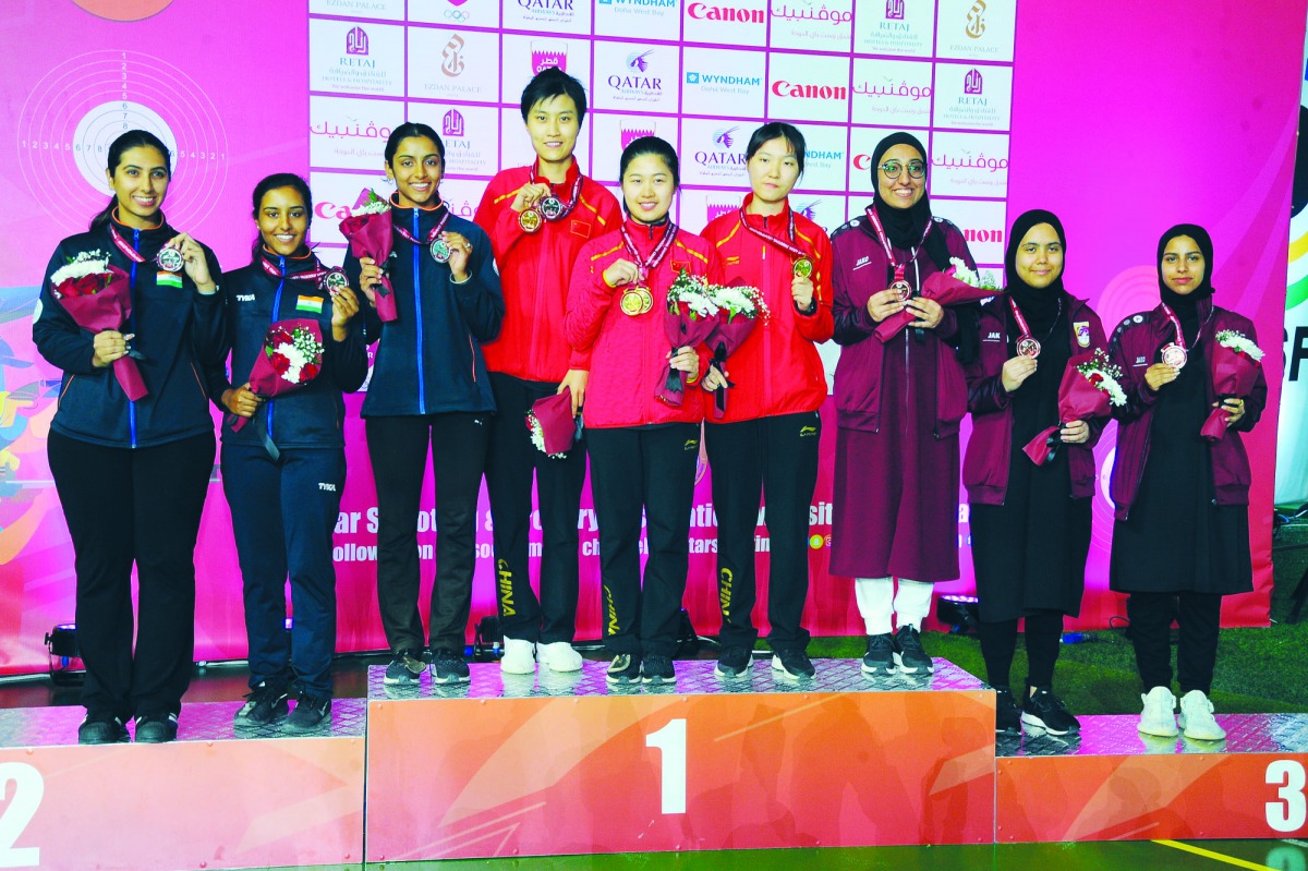 The podium winners of the Junior Women’s Skeet Team event, posing for a photograph at the Losail Shooting Range yesterday. Team Qatar won the bronze medal while China finished on top. India won the silver. BOTTOM: Shooters in action. Picture: Ebrahim Kutt