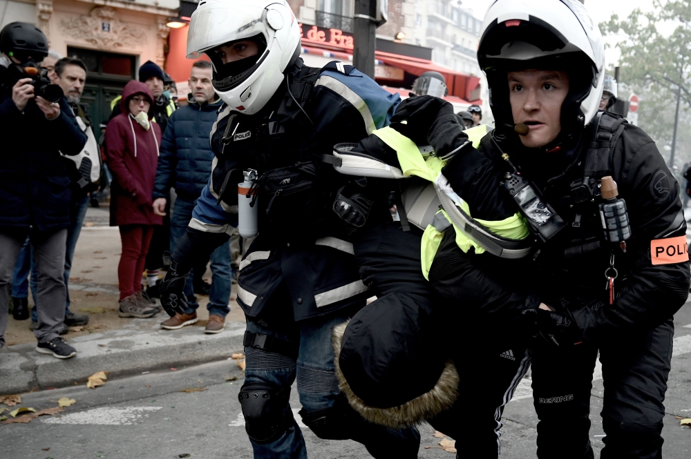 Police officers detain a man during clashes with protesters on November 16, 2019, near Place d'Italie in Paris, on the sidelines of a demonstration of the 