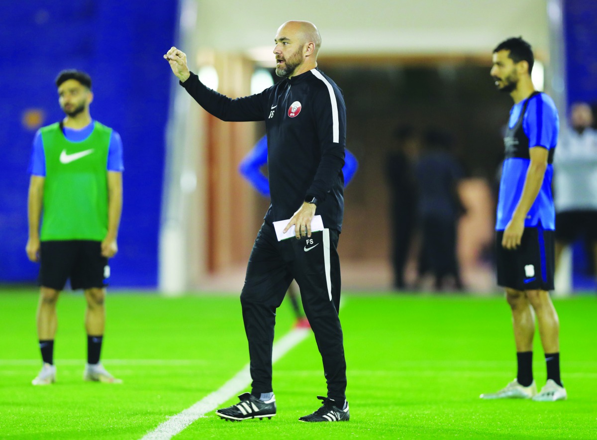 Qatar coach Felix Sanchez (C).