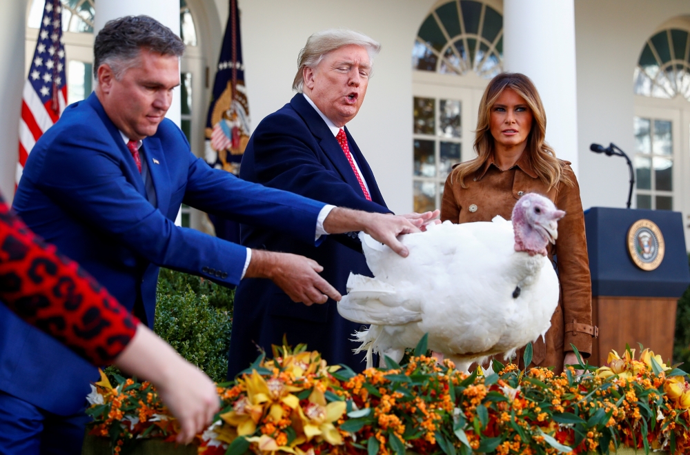 U.S. President Donald Trump pardons one of the 72nd National Thanksgiving Turkeys as Wellie Jackson, who raised the turkey, holds it as first lady Melania Trump looks on during turkey pardoning ceremonies in the Rose Garden of the White House, November 26