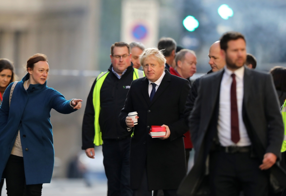 Britain's Prime Minister Boris Johnson (C) visits the scene of a stabbing, on London Bridge in the City of London on November 30, 2019. AFP / POOL / SIMON DAWSON