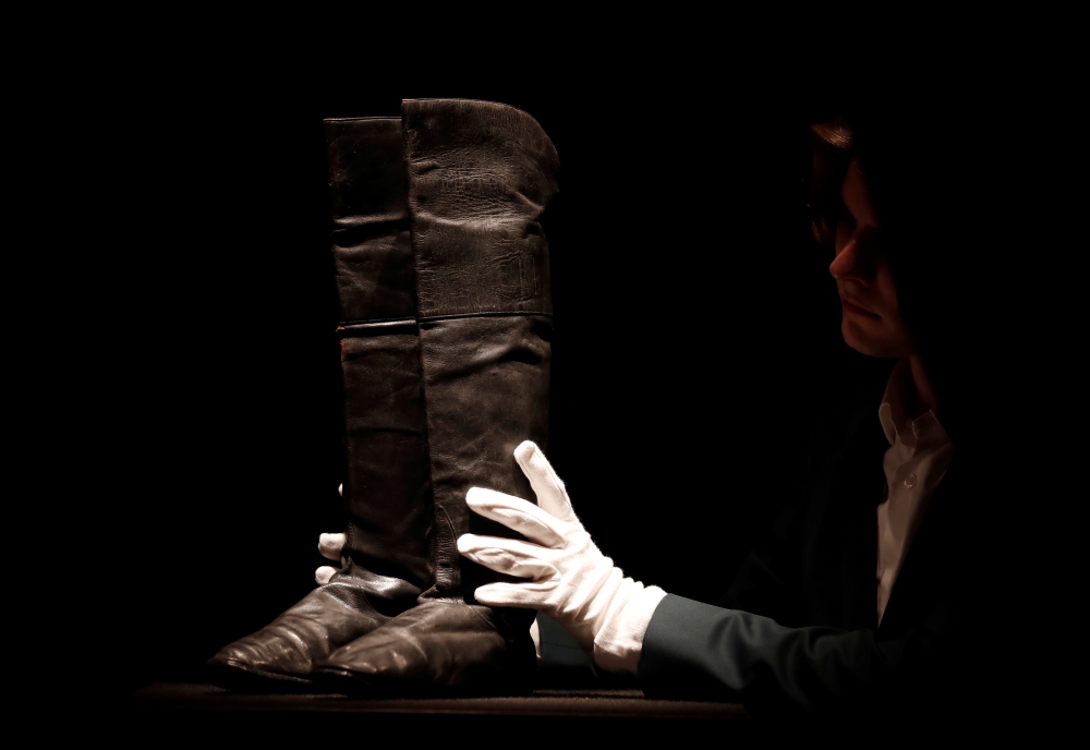 Boots that might have be worn by French statesman Napoleon during his final exile in Saint-Helena are handled before being put on auction at Drouot auction house in Paris, November 28, 2019. Reuters/Christian Hartmann