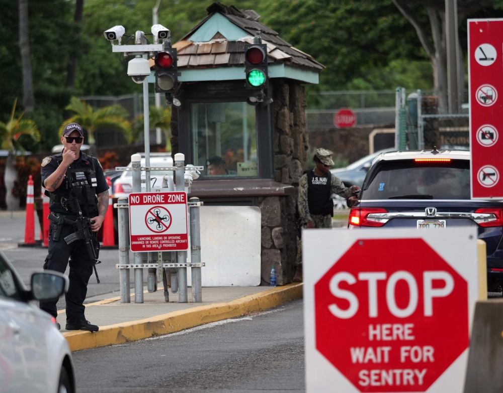 A guard stands by at the Nimitz Gate of Pearl Harbor in Hawaii shortly after a sailor fatally shot two civilians at the Pearl Harbor Naval Shipyard in Honolulu, Hawaii on December 4, 2019. AFP / Ronen Zilberman 