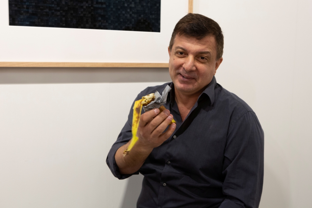 David Datuna shows the remains of the artwork 'Comedian' by the artist Maurizio Cattelan at Perrotin stand in Art Basel in Miami Beach, Florida, December 7, 2019. REUTERS/Eva Marie Uzcategui