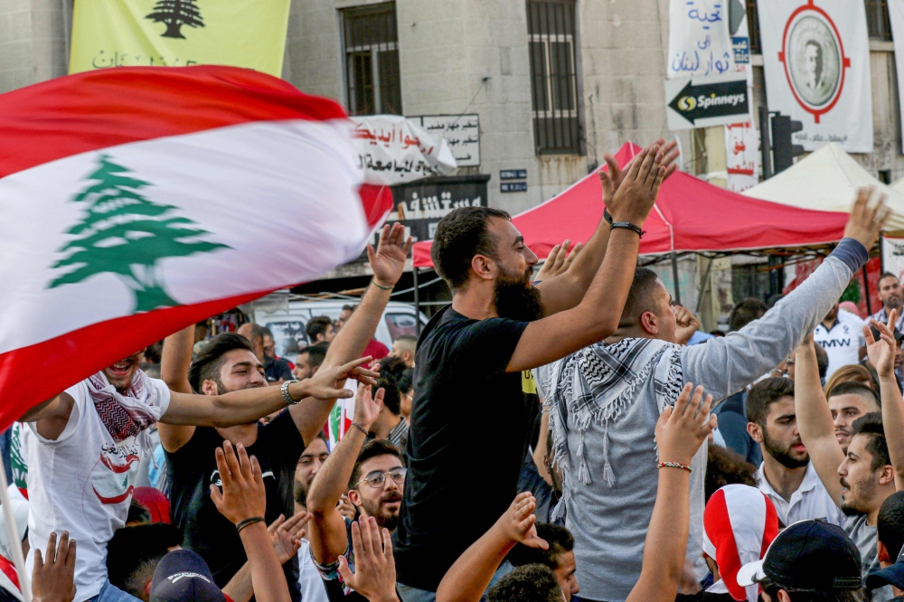 FILE PHOTO: Lebanese protesters celebrate the resignation of Saad Hariri in the southern city of Sidon on October 29, 2019 on the 13th day of anti-government protests. AFP / Mahmoud Zayyat