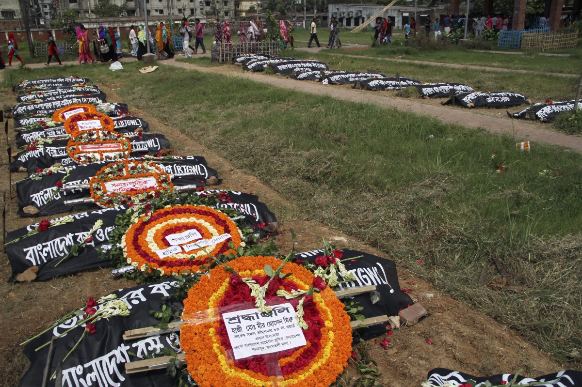 Relatives of victims of the Rana Plaza building collapse pay their respects at a graveyard in Dhaka on April 24, 2016. AFP / Rehman Asad