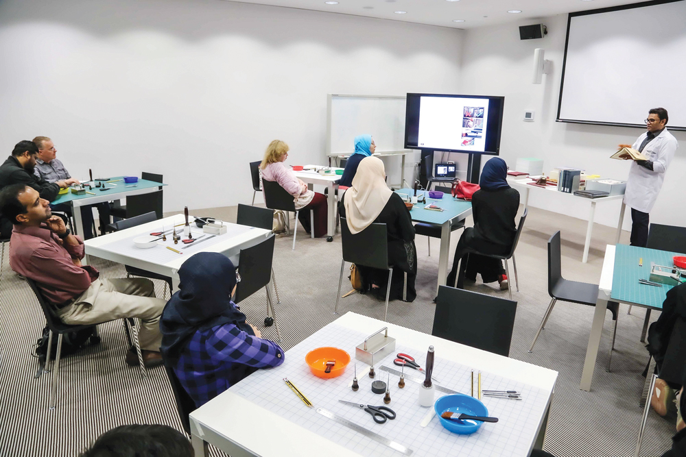 Conservation technician Chanaka Perera teaching participants the art of creating beautiful notebooks by hand at the two-day workshop at Qatar National Library. 