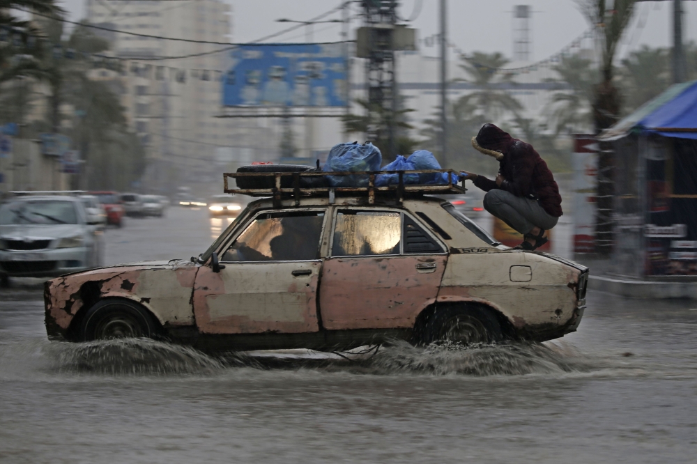 A car drives through a flooded road following heavy rain in Gaza City on December 27, 2019. AFP / Mohammed Abed 