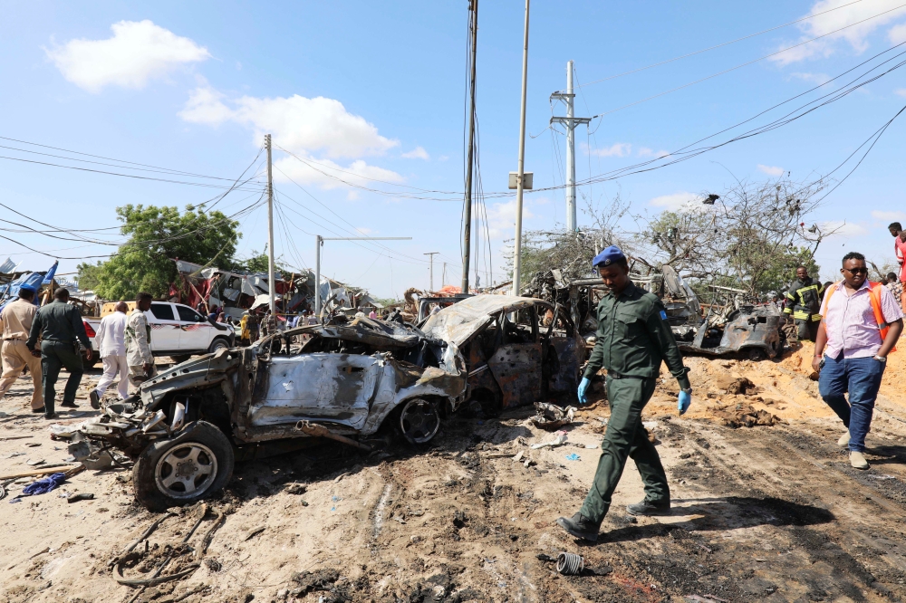 A Somali police officer walks past a wreckage at the scene of a car bomb explosion at a checkpoint in Mogadishu, Somalia December 28, 2019. REUTERS/Feisal Omar