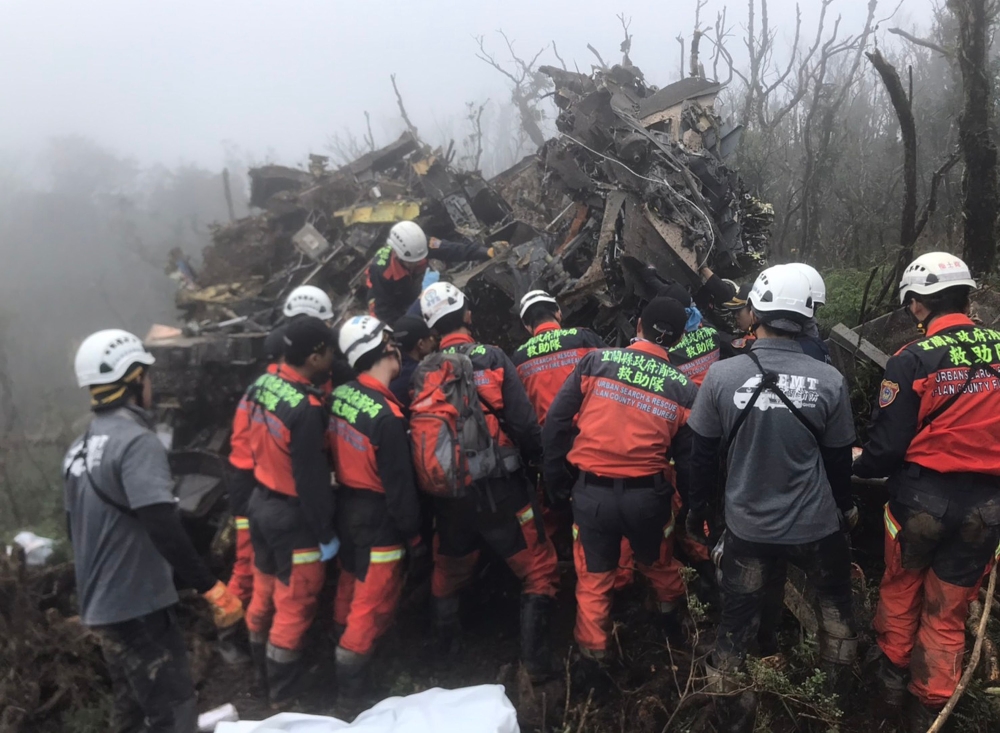 This handout picture released by the Yilan County Fire Department on January 2, 2020, shows rescuers searching for survivors after a military Black Hawk helicopter smashed into mountains in Yilan county near Taipei. AFP / Yilan County Fire Department