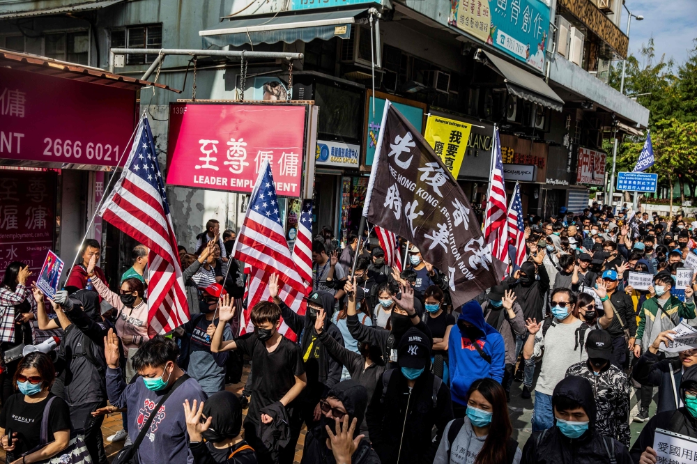 Pro-democracy protesters march along a street during a demonstration against parallel trading in Sheung Shui in Hong Kong on January 5, 2020. AFP / ISAAC LAWRENCE