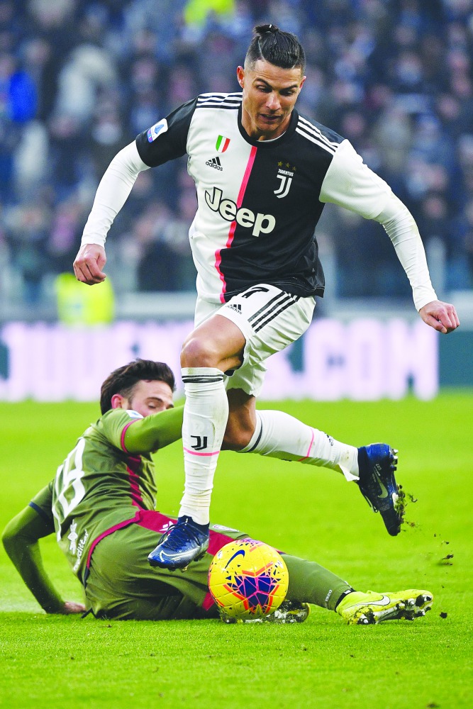 Juventus' Portuguese forward Cristiano Ronaldo outruns Cagliari's Uruguayan midfielder Nahitan Nandez (Bottom) during the Italian Serie A football match Juventus vs Cagliari on January 6, 2020 at the Juventus Allianz stadium in Turin. AFP / Marco Bertorel